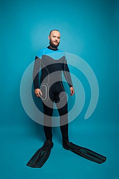 Man diver standing on blue studio background