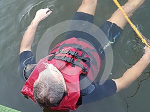 a man in a diving suit and a life jacket lies on the surface of the water