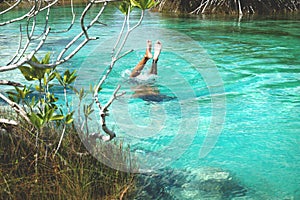 Man diving into turquoise water of seven coloured lagoon, Bacalar, Quintna Roo, Mexcico