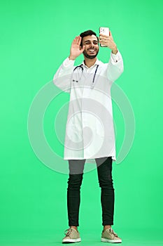 A man doctor conversate with phone on a green background photo