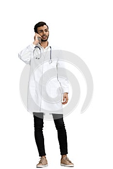 A man doctor conversate with phone on a white background photo