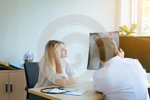 Man doctor examining X-ray results to woman patient,Infertility counseling and suggestion using new technology