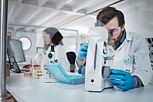 Man, doctor and forensic scientist with microscope for examination, experiment or test at laboratory. Male in science