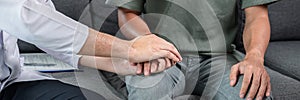 Man doctor holding hands with patient to giving encouraging while he receive to listening about result