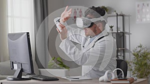 Man doctor holding a video conference while sitting in the office in vk glasses