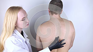 A man at the doctor`s appointment with back pain. Treatment of spinal deformity and stoop. Osteoporosis, kyphosis, lordosis, or sc