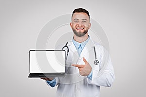 Man doctor showing laptop screen, empty display