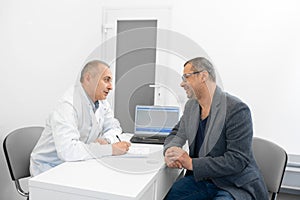 Man doctor urologist advises a male patient photo