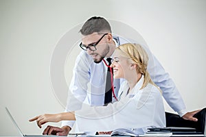 man doctor and woman doctor Smiling working together on laptop i