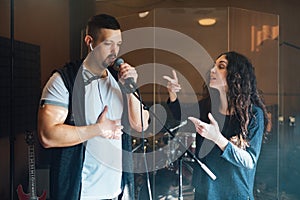 A man does chanting with a teacher in vocal lesson pointing to the correct breathing in the chest