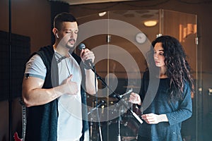 A man does chanting with a teacher in vocal lesson pointing to the correct breathing in the chest