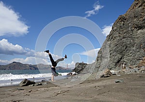 Man does a Handstand in on beach in front of the Golden Gate Bridge