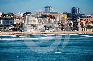 Man does stand up paddle overlooking the coast of Estoril near Lisbon, Portugal