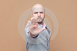 Man does stop sign with palm, demonstrates prohibition and restriction, refuses something, says no.