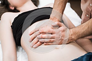 A man does a woman a massage of the abdomen, osteopathy 3