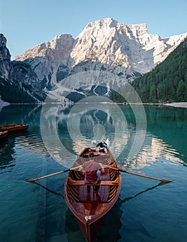 Man and dog in a boat on a mountain lake. Trip with a pet to Italy. Australian Shepherd Dog and its owner