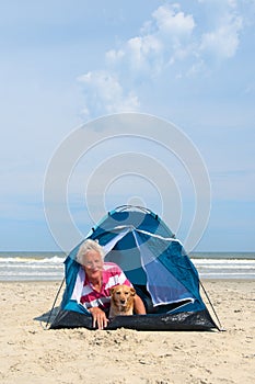 Man with dog camping in shelter at the beach