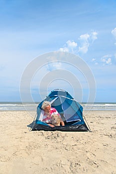 Man with dog camping in shelter at the beach