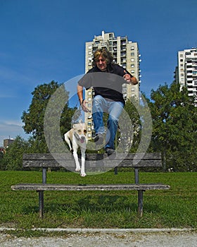 Man And Dog Jumping Over The Bench