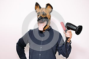 Man with dog mask holding hairbrush and hairdryer