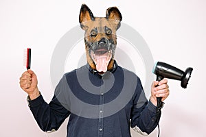 Man with dog mask showing hairbrush and hairdryer