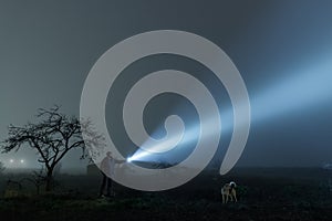 Man and dog searching with flashlight in outdoor