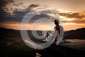 A man with a dog at sunset. walk with a pet. Australian Shepherd and owner in nature