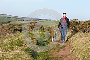 Man With Dog Walking Along Coastal Path