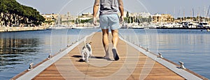 A man with a dog walking on the floating pier
