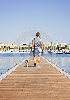 A man with a dog walking on the floating pier