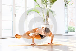 Man doing an Astavakrasana or eight-angle pose