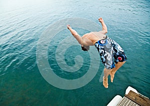 Man doing back-flip into lake