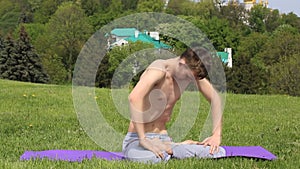Man doing belly motion Nauli Kriya Yoga technique on the grass in India