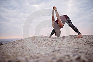 Man doing the clasp hands forward fold pose outdoors