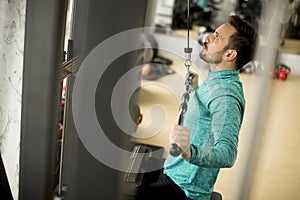 Man doing excersise on a lat machine in gym