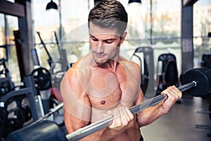 Man doing exercises with barbell in gym