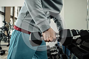 A man doing exercises biceps with dumbbell in gym. Fitness, workout and traning concept