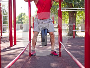 A man is doing exercises on his feet. Sporty and healthy young man with perfect body exercising outdoors.