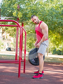 A man is doing exercises on his feet. Sporty and healthy young man with perfect body exercising outdoors.