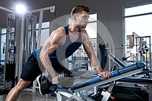 Man doing exercises with one dumbbell in the gym
