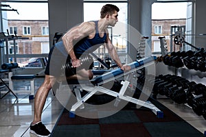 Man doing exercises with one dumbbell in the gym