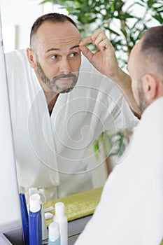 man doing eyebrows with tweezers photo