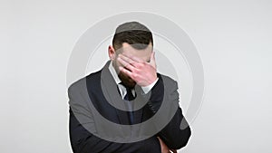 Man doing facepalm gesture, touching head.