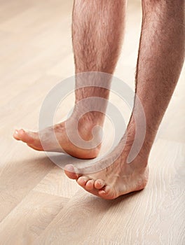 Man doing flatfoot correction gymnastic exercise toe lifts at home