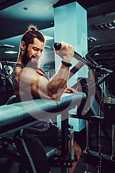 Man Doing Heavy Weight Exercise For Biceps On Machine In A Gym