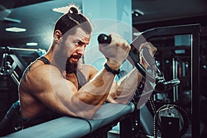 Man Doing Heavy Weight Exercise For Biceps On Machine In A Gym