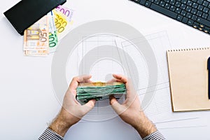 Man doing his accounting. close up of man hands with euro money, tax report form: business, finance, saving, banking concept.