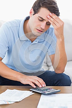 Man doing his accounts with a calculator