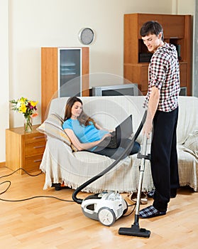 Man doing house cleaning with vaccuum cleaner