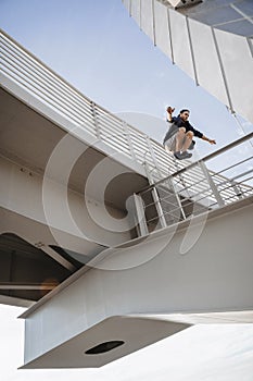 Man doing huge parkour jump from the bridge